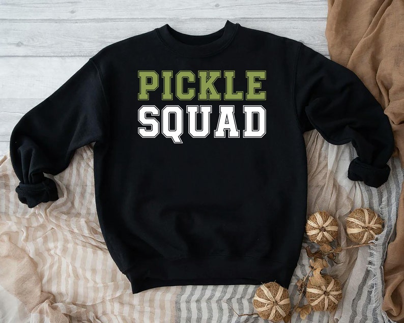 May include: Black sweatshirt with the text "Pickle Squad" in green and white letters.