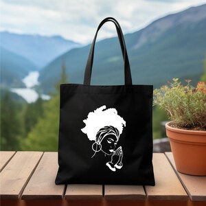 a black tote bag with a picture of a woman's head