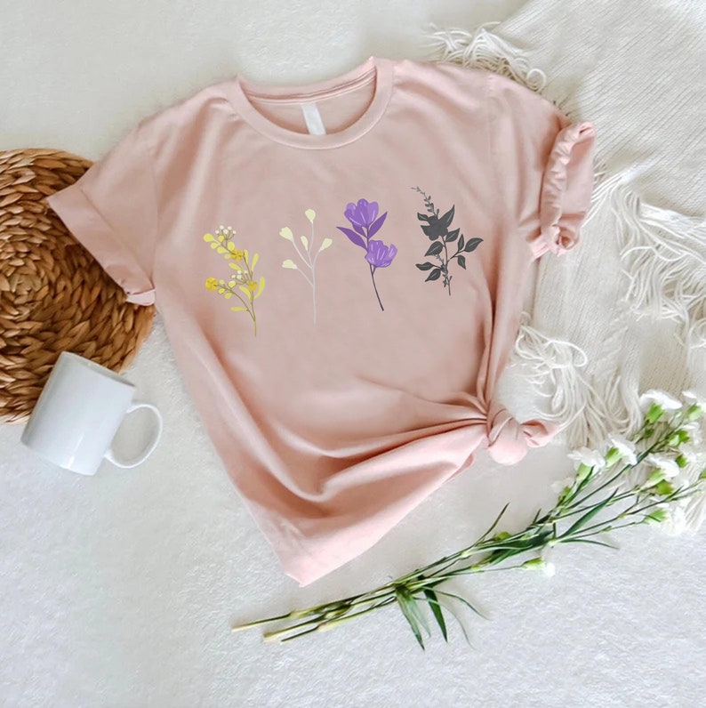 a pink t - shirt with purple flowers on it
