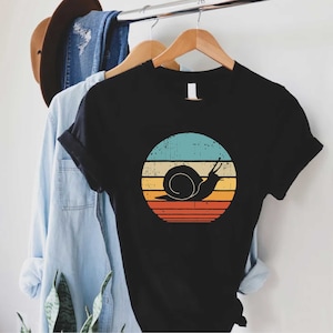 a black shirt with a snail on it