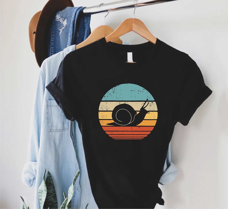 a black shirt with a snail on it