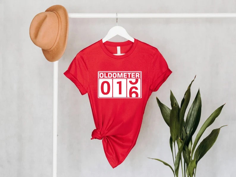 May include: Red t-shirt with a white graphic that says "Oldometer 016".