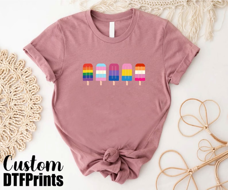 a pink shirt with three popsicles on it