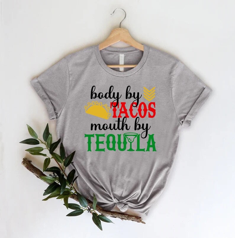 May include: Gray t-shirt with the text "body by tacos mouth by tequila" in red, yellow, and green. A yellow taco and a green margarita glass are included in the design.