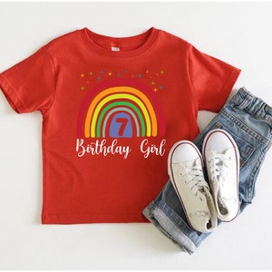 Peut inclure: T-shirt rouge avec un arc-en-ciel et le texte "7 Birthday Girl".