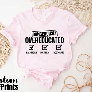 a pink shirt that says dangerous is overeducated