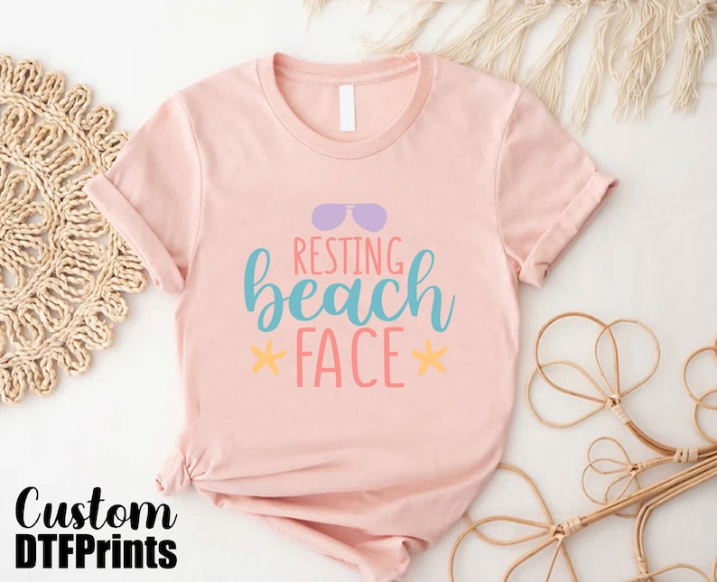 a pink shirt that says resting beach face
