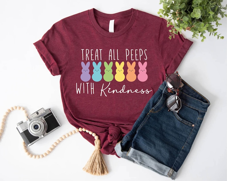 May include: A maroon t-shirt with the text "Treat all peeps with kindness" and a row of colourful marshmallow peeps.