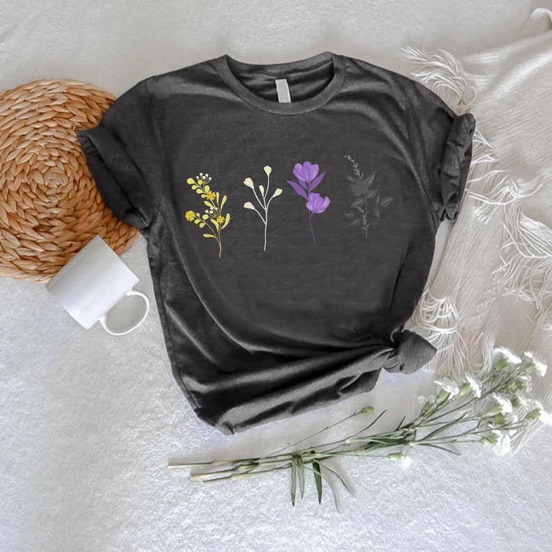 a t - shirt with flowers on it next to a straw hat