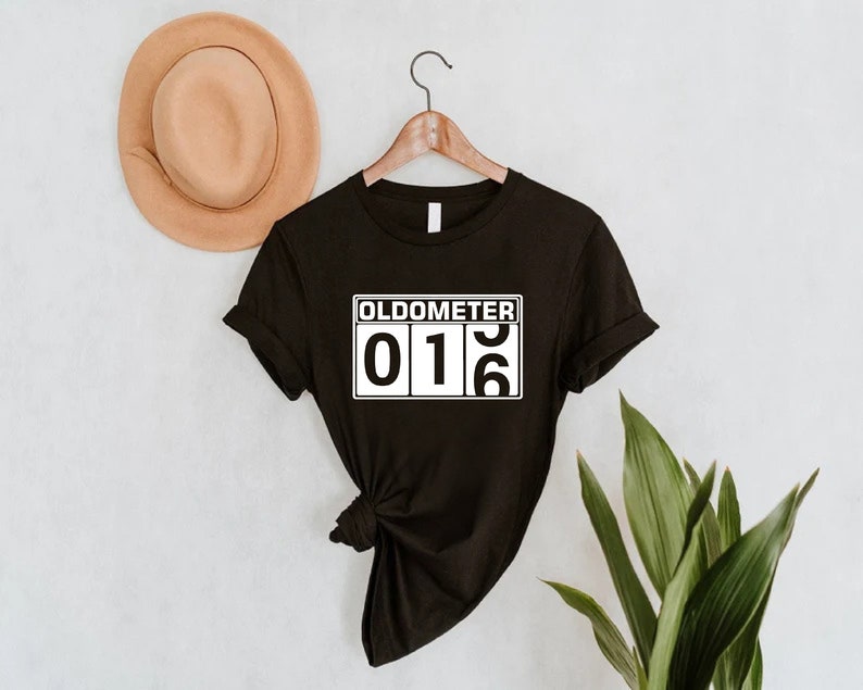May include: Black t-shirt with a white graphic that says "Oldometer 016".