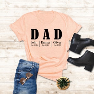a t - shirt that says dad and a pair of jeans