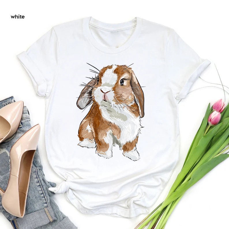 a white shirt with a brown and white rabbit on it