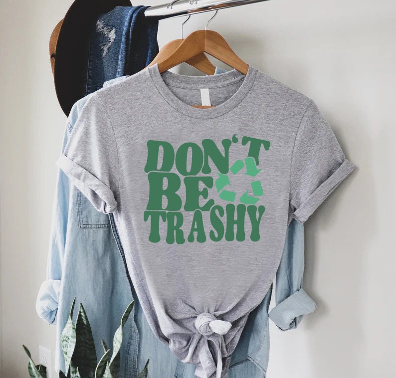 May include: Gray t-shirt with a green graphic that says "Don't Be Trashy" with a green recycle symbol.