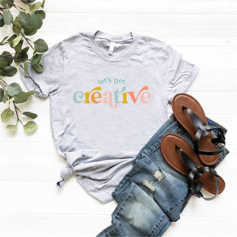 a t - shirt that says let's get creative on it