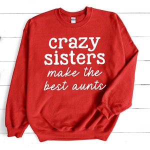 a red sweatshirt that says crazy sisters make the best aunts