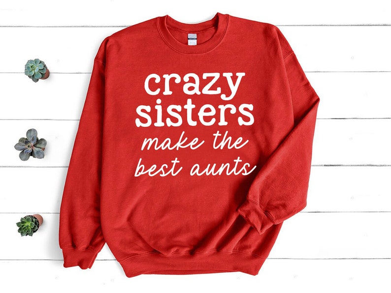 a red sweatshirt that says crazy sisters make the best aunts