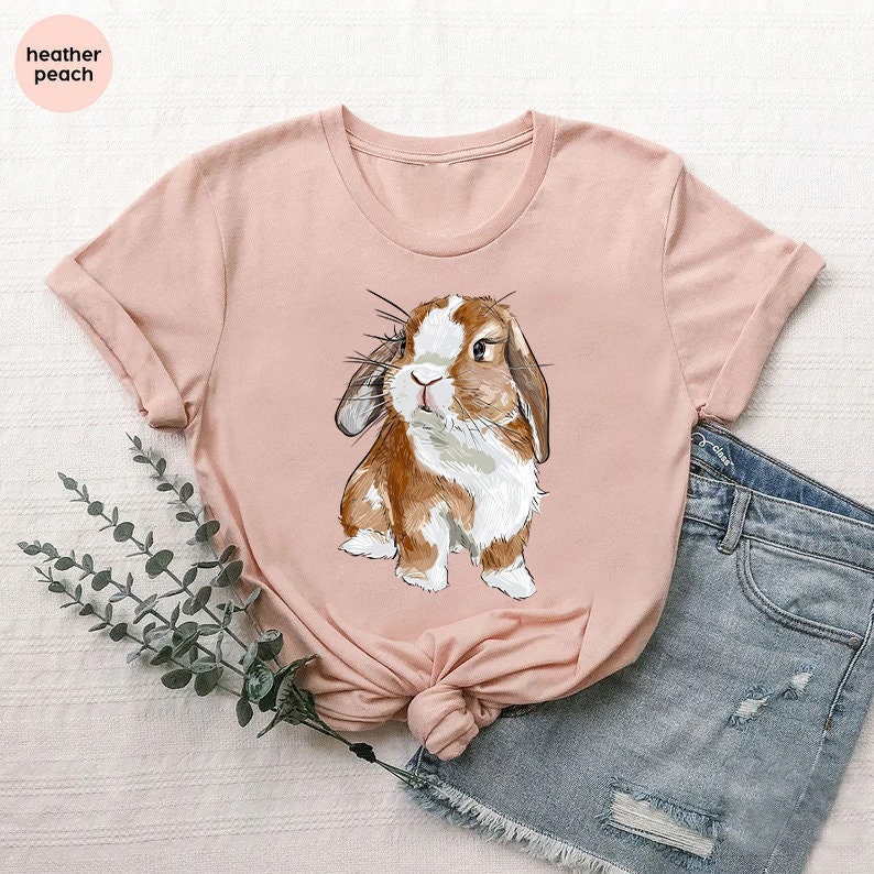 a pink shirt with a brown and white rabbit on it