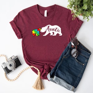 a t - shirt that says autism with a bear on it