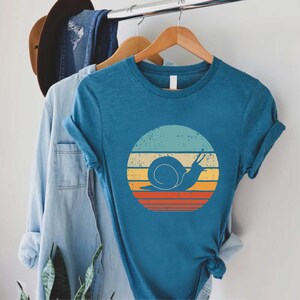 a blue shirt with a snail on it