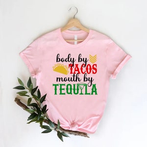 a pink shirt that says body by tacos, mouth by tequila