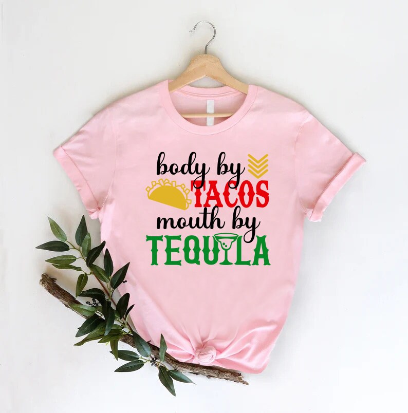 a pink shirt that says body by tacos, mouth by tequila