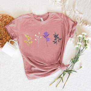 a pink t - shirt with a picture of flowers on it