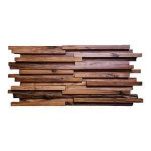 May include: A wall panel made of reclaimed wood planks, arranged in a staggered pattern. The wood is a mix of brown and dark brown shades, with a rustic, weathered look.