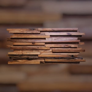 May include: A wall panel made of reclaimed wood planks, arranged in a staggered pattern. The wood is a mix of light and dark brown tones, with a rustic and weathered look.