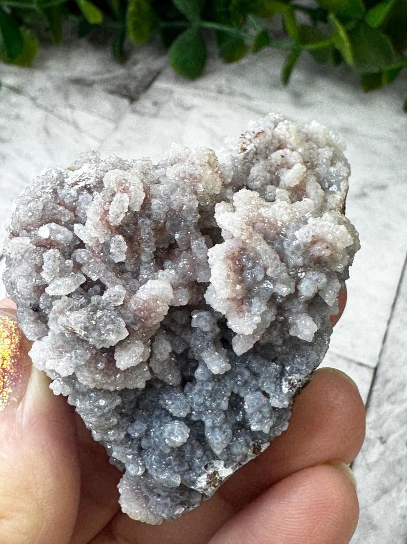 May include: A cluster of gray and purple amethyst crystals with a rough, textured surface. The crystals are clustered together in a heart shape.