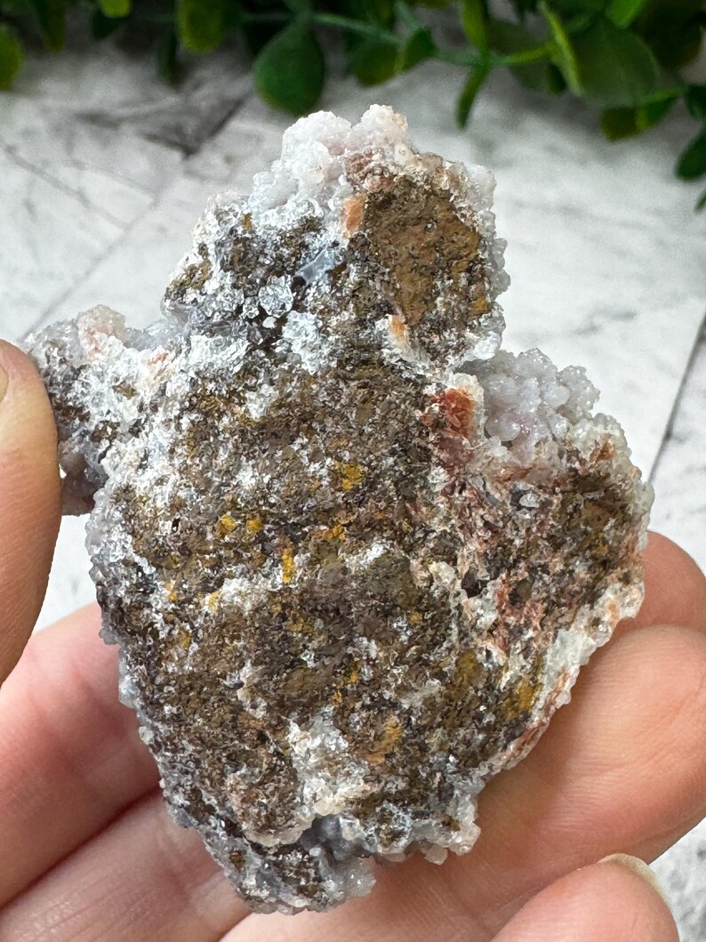 May include: A cluster of white and brown agate with a rough, textured surface. The agate has a natural, earthy look and is a great example of this type of crystal.