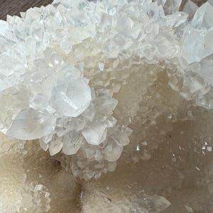 以下が含まれることがあります： 多数の鋭く尖った先端を持つ、透明で半透明な水晶の結晶クラスター。この鉱物形成は、小さく密集した点から大きくはっきりとしたプリズムまで、さまざまなサイズの結晶を持つ、ギザギザで多面的な表面を特徴としています。