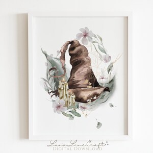 Pode incluir: Uma ilustração em aquarela de um chapéu de mago marrom com uma vela dourada dentro, cercada por flores rosa e folhas verdes.