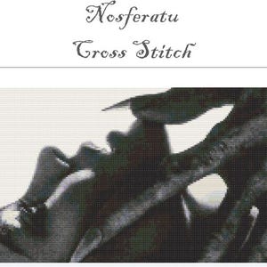 May include: Black and white cross stitch pattern featuring a scene from the movie Nosferatu. The image shows a close-up of a face and hand with the text "Nosferatu Cross Stitch" at the top.