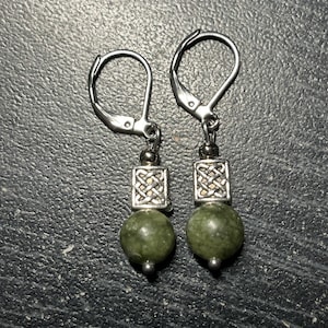 May include: A pair of silver Celtic knot earrings with green stone beads.