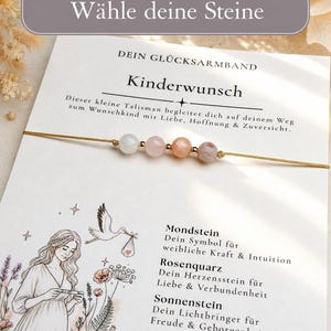 Könnte beinhalten: Ein zartes Armband mit vier kleinen, glatten, mehrfarbigen Edelsteinperlen an einem dünnen goldfarbenen Band, präsentiert auf einer weißen Karte mit deutschem Text, einer Strichzeichnung einer Person und einem Storch mit einem Bündel.