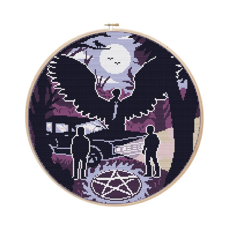 May include: A cross-stitch embroidery hoop featuring a scene with two figures, a car, and a large winged figure. The design uses shades of purple, black, and white, with a full moon in the background. A pentagram is at the bottom.