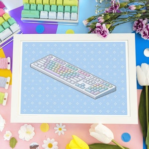 May include: A white framed cross-stitch pattern with a blue background and a colorful keyboard design. The keyboard has pastel colored keys and a white border.