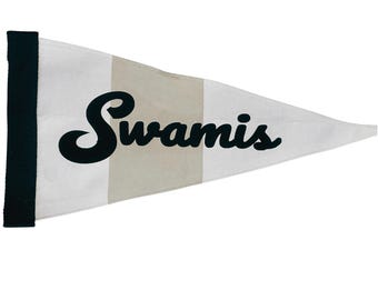 May include: A white pennant flag with the word "Swamis" in black script. The flag has a black border on the left side and a vertical tan stripe. The pennant is triangular in shape.