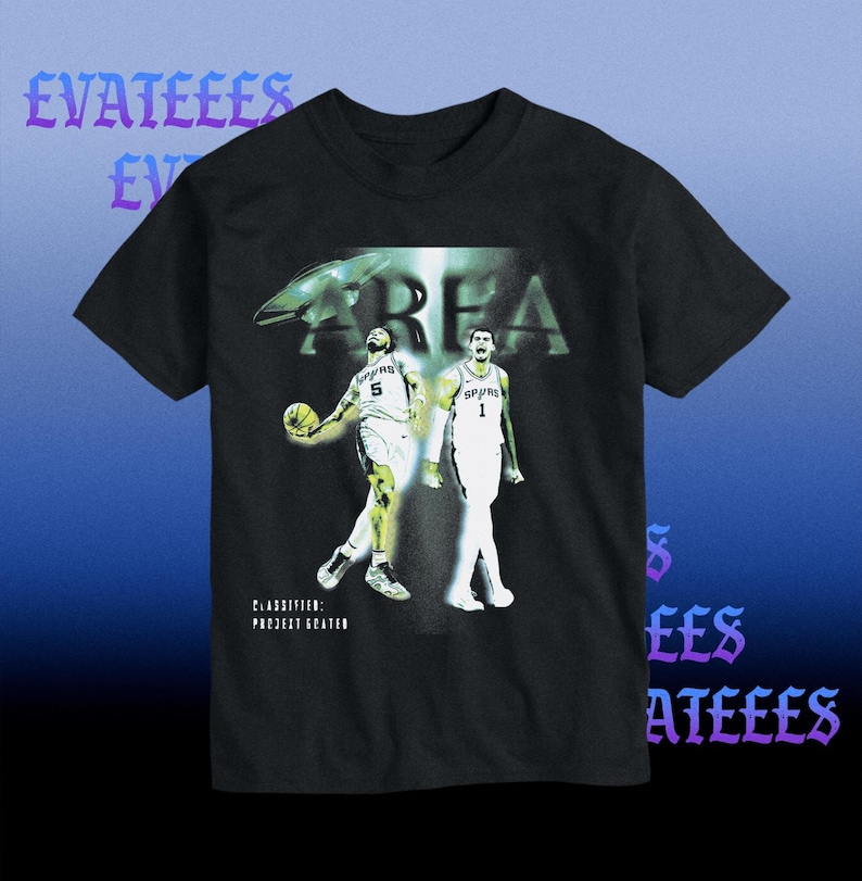K&ouml;nnte beinhalten: Schwarzes T-Shirt mit einer Grafik von zwei Basketballspielern in wei&szlig;en Trikots. Das Wort "AREA" ist &uuml;ber den Spielern aufgedruckt, darunter der Text "CLASSIFIED: PROJECT GREATER". Das T-Shirt hat einen blauen Farbverlauf im Hintergrund.