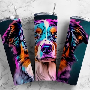 Puede incluir: Tres vasos de acero inoxidable con un diseño abstracto colorido de un perro pastor australiano. Los vasos son negros, azul verdoso y blancos con un diseño rosa, azul, naranja y amarillo.