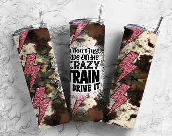 May include: Three stainless steel tumblers with lids and straws. The tumblers feature a cowhide and camouflage pattern with a pink glitter lightning bolt design. One tumbler has the text "I don't just ride on the crazy train, drive it."