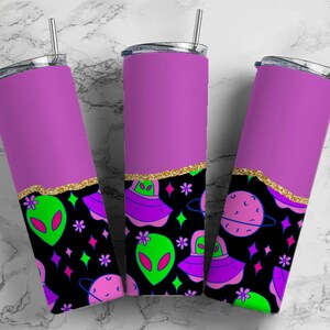 May include: Three stainless steel tumblers with a purple top and a black bottom. The bottom features a pattern of green aliens, stars, planets, and glitter.