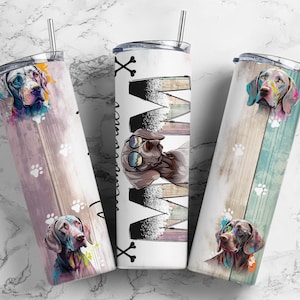 May include: Three stainless steel tumblers with a colorful dog design. The tumblers have a wood grain background with paw prints. One tumbler has the word "Mom" written in black with a skull and crossbones design.