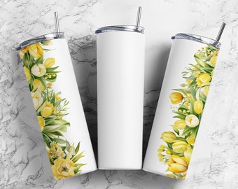 Op de afbeelding: Drie witte roestvrijstalen bekers met deksels en rietjes. Twee bekers hebben een aquarelontwerp van gele tulpen en groen langs de zijkant. De derde beker is effen wit.