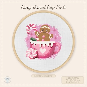 May include: Cross-stitch pattern of a pink gingerbread man in a pink cup with a heart, candy cane, and pink swirl candy. The text "Gingerbread Cup Pink" is at the top. The pattern is 77 x 75 stitches, beginner level.