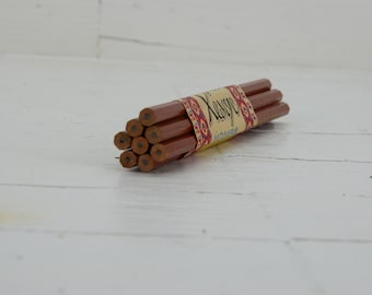 May include: A bundle of brown wooden pencils wrapped in a paper label with the text "Kasype" and a colorful pattern.