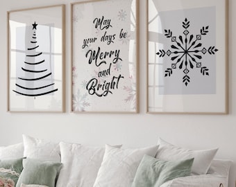 May include: Three framed prints with a white background. The left print features a black stylized Christmas tree. The center print features the text "May your days be Merry and Bright" in black cursive lettering with a white snowflake background. The right print features a black snowflake on a white background.