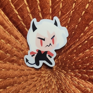 May include: A sticker of a cartoon character with white hair, red eyes, and a black outfit. The character has a grumpy expression and is wearing a black outfit with a red collar.