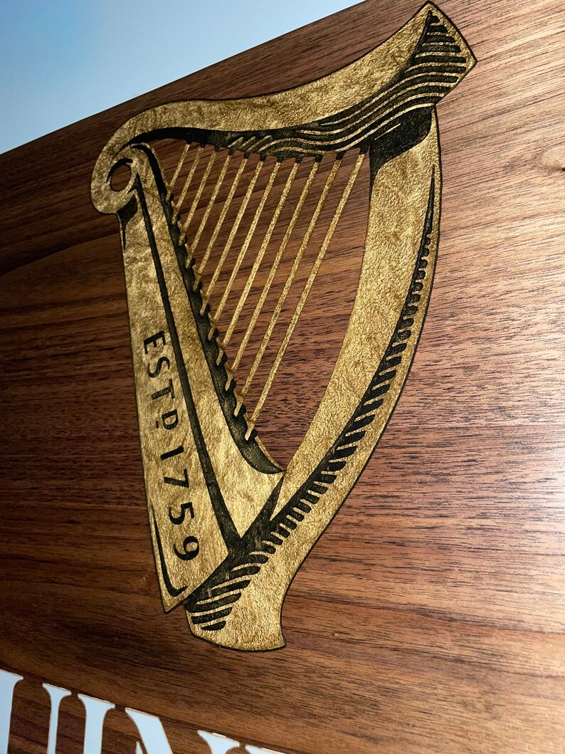 Pu&ograve; includere: Un cartello di legno con un'arpa dorata e il testo "ESTD 1759".