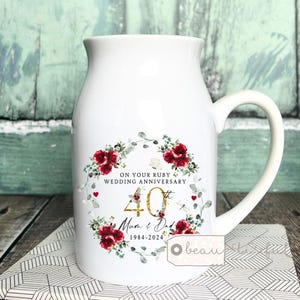 May include: White ceramic mug with a floral design and gold lettering. The mug says "On your Ruby Wedding Anniversary 40th Mum & Dad 1984-2024".